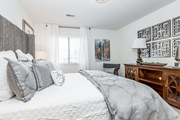 Raleigh apartment for rent - A bedroom with a large bed and a wooden dresser at Regency Park Apartment Homes, North Carolina