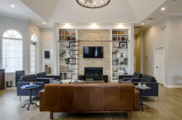 Nashville apartment for rent - A living room with a brown leather couch and a stone fireplace.