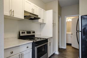 Nashville apartment for rent - a kitchen with white cabinets and black appliances
