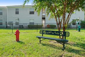 St. Marys apartment for rent - a bench and a fire hydrant in a grassy area with a building in the background
