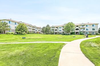 Curved sidewalk through landscaped community lawn