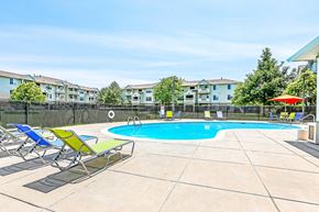 Brighton apartment for rent - Community pool with colorful loungers and patio furniture at Riverwalk Apartments, Colorado