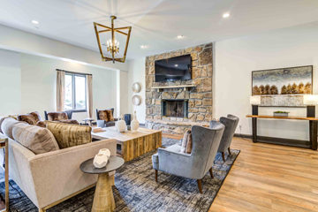 Knoxville apartment for rent - A living room with a stone fireplace and a large painting on the wall.