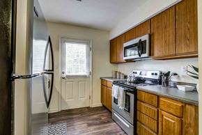 Knoxville apartment for rent - kitchen with appliances, wood cabinetry, and hardwood-style flooring