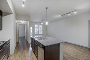 Burleson apartment for rent - Kitchen island and dining area with wood style flooring, granite countertop, track lighting, large windows with mini blinds and ceiling fan with light