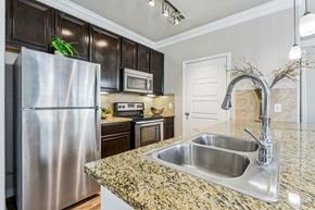 Pflugerville apartment for rent - A kitchen with granite countertops and stainless steel appliances.