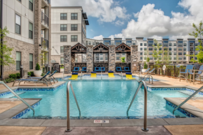 Nashville apartment for rent - A large outdoor swimming pool with a diving board and lounge chairs.