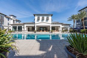 Orlando apartment for rent - A large white house with a pool in front.