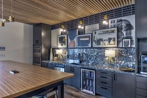 Burleson apartment for rent - A modern kitchen with a wooden table and black cabinets.