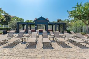 Tallahassee apartment for rent - A gazebo is surrounded by lounge chairs on a brick patio.