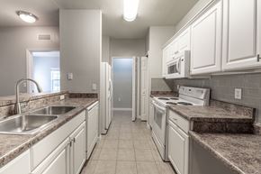 Tallahassee apartment for rent - A kitchen with white cabinets and granite countertops.