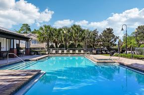 Jacksonville apartment for rent - A large swimming pool with a wooden deck and a fence surrounding it.