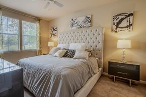 Jacksonville apartment for rent - A bedroom with a large bed and a ceiling fan.