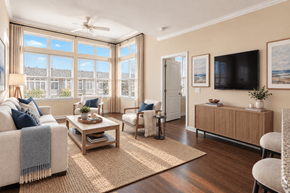 Waldorf apartment for rent - A living room with a large window, a sofa, a coffee table, and a television.