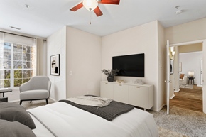 Charlotte apartment for rent - a bedroom with a large window and a ceiling fan