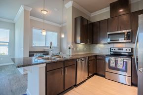 Austin apartment for rent - A kitchen with a stove top oven and microwave.