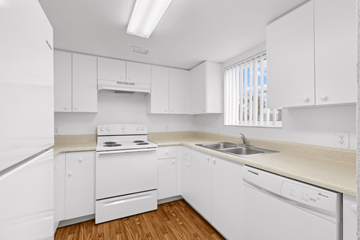Lake Park apartment for rent - A white kitchen with a stove, sink, and cabinets.