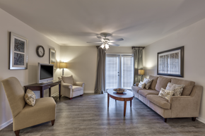 Nashville apartment for rent - A living room with a beige sofa, two chairs, a coffee table, and a television.