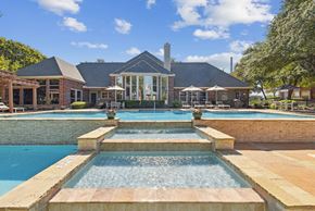 San Antonio apartment for rent - A house with a pool and a waterfall in front.