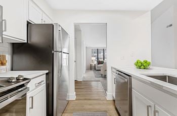 A kitchen with a black refrigerator and white cabinets.