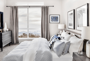 Denver apartment for rent - A bedroom with a large bed and a window overlooking the mountains.