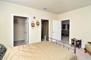 Buford apartment for rent - Decorated bedroom with tan carpet, beige walls, and ceilings. Bed lies on the left side of the room with a closet in the back