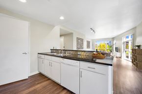 Denver apartment for rent - A kitchen with white cabinets and a wooden floor.
