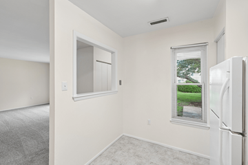Waldorf apartment for rent - A white refrigerator sits in a kitchen next to a window.