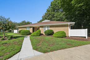 Waldorf apartment for rent - A house with a white picket fence and green bushes in front.