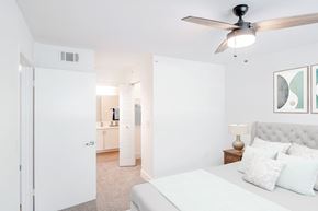 Deerfield Beach apartment for rent - A bedroom with a bed, a ceiling fan, and a nightstand with a lamp.