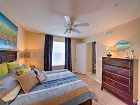 Jacksonville apartment for rent - Furnished model bedroom with carpet flooring, multi speed ceiling fan, drawer set, and large window for natural lighting