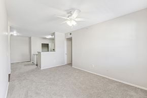 Denton apartment for rent - A spacious room with a ceiling fan and carpeted floor.