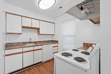 Virginia Beach apartment for rent - A kitchen with white cabinets and a white stove top oven.