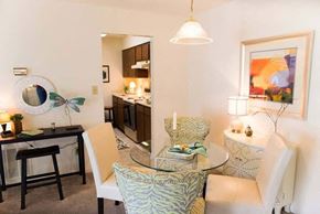 High Point apartment for rent - A modern dining room with a glass table and chairs at Fox Hollow Apartment Homes, High Point, 27265