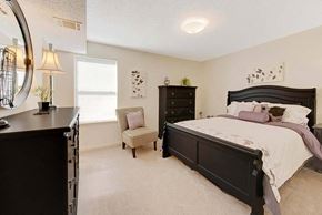 High Point apartment for rent - A bedroom with a large bed and a chair by the window at Fox Hollow Apartment Homes, North Carolina, 27265