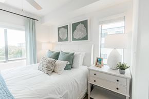 Key West apartment for rent - a bedroom with a bed with pillows and a dresser with a lamp and