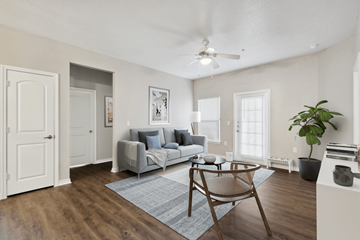 Austin apartment for rent - A living room with a grey couch and a wooden chair.