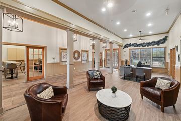Denton apartment for rent - A living room with brown leather chairs and a white coffee table.