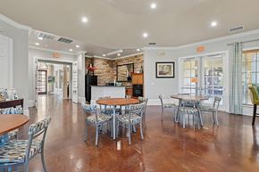 Fort Worth apartment for rent - A clubhouse lounge area with wooden tables surrounded by chairs.