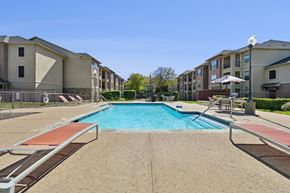 Fort Worth apartment for rent - A swimming pool surrounded by apartment buildings.