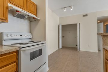 Houston apartment for rent - A white stove and oven in a kitchen with wooden cabinets.