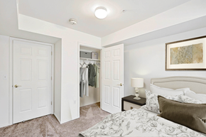 Farmington apartment for rent - Carpeted bedroom with bed and nightstand facing the opened closet door