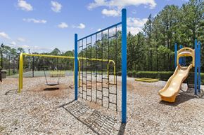 Warner Robins apartment for rent - A playground with a yellow slide and a blue fence.