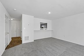 Stafford apartment for rent - A spacious, empty room with a grey carpet and white walls.