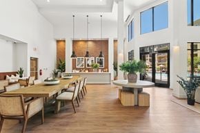 Kennesaw apartment for rent - A modern dining room with a long wooden table and chairs.