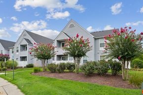 Waldorf apartment for rent - A row of houses with trees and flowers in front.