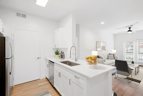 Denver apartment for rent - A modern kitchen with white cabinets and a black refrigerator.