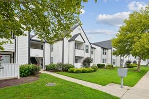 Waldorf apartment for rent - Apartment complex with a white fence and green trees.