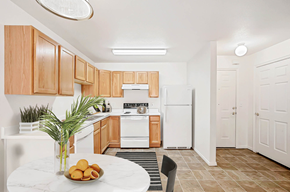 Farmington apartment for rent - Kitchen with wooden cabinets and white appliances and small dining table