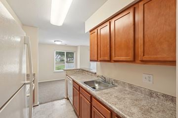 Waldorf apartment for rent - A kitchen with wooden cabinets and a granite countertop.